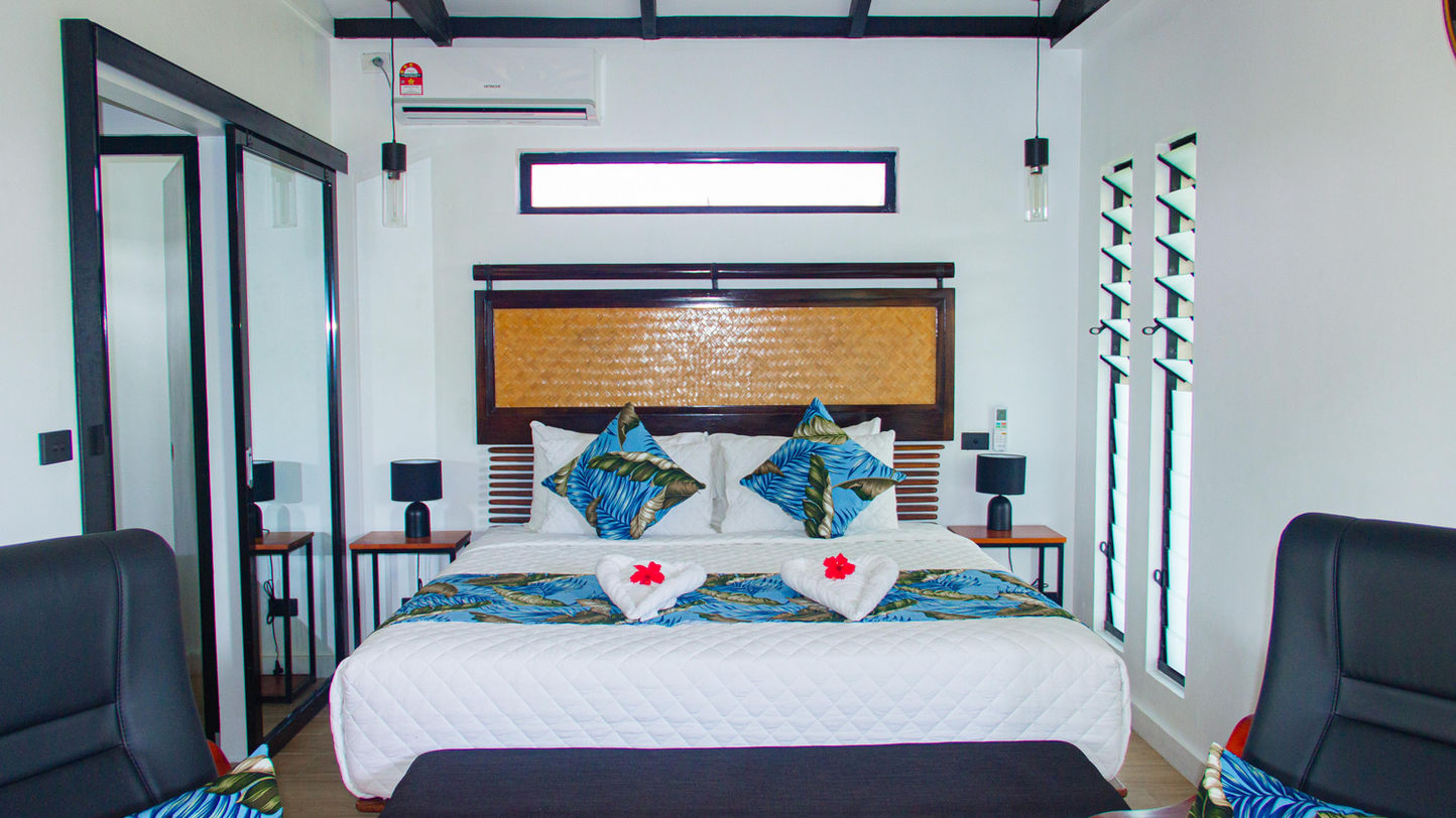 Deluxe Villa — a bright garden-view room with a separate bedroom and patio
